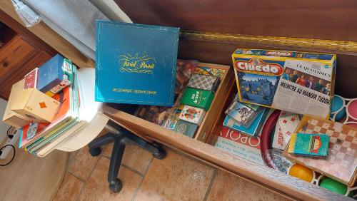 a table with toys and books on a shelf at La p'etit maison rose in Malouy