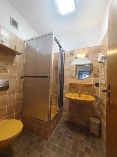 bagno con doccia e lavandino giallo di Ferienhaus-Schönwald im Herzen des Schwarzwaldes 2-Zimmer mit Terrasse und Whirlpool App15 a Schönwald