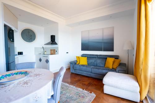 a living room with a couch and a table at Perla Marina Sea View Apartment in Catania