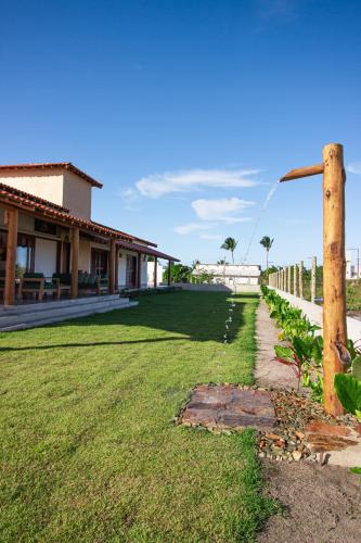 a yard with a fence and a house at Casa Licuri Corumbau in Corumbau