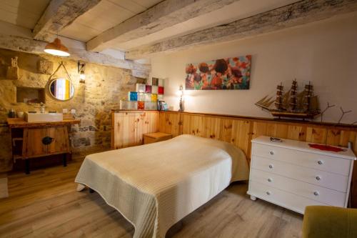 une chambre avec un lit et un lavabo dans l'établissement Le gentil coquelicot, à Saint-Pompont