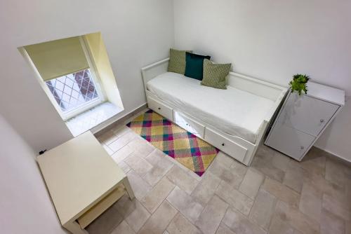 a small bedroom with a bed and a window at RivieraRent Dadda House in Orco Feglino
