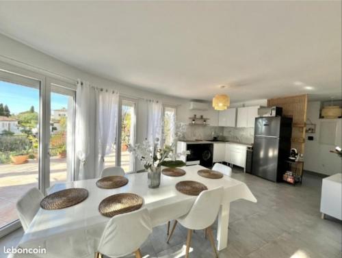 une salle à manger blanche avec une table et des chaises dans l'établissement VILLA BANDOL PROCHE du PORT et DES PLAGES, à Bandol