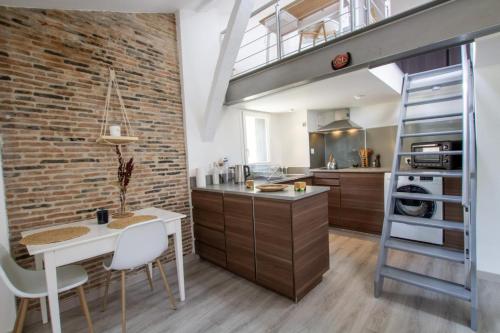 une cuisine avec un mur en briques dans l'établissement Soleil levant, à Périgueux