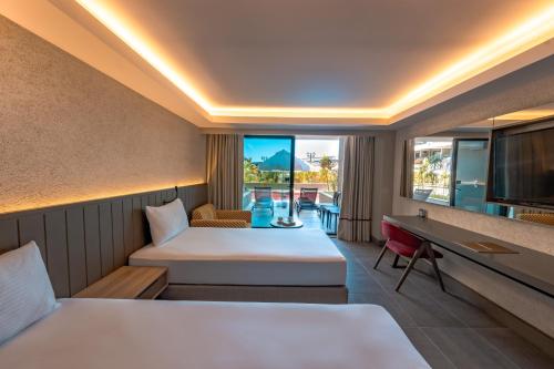 a hotel room with two beds and a tv at The X Belek in Belek