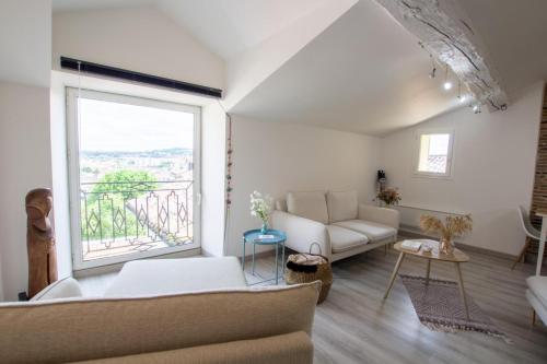 un salon avec un canapé et une grande fenêtre dans l'établissement Soleil levant, à Périgueux