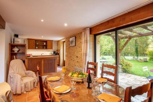 - une cuisine et une salle à manger avec une table et un bol de fruits dans l'établissement Le pourqueyrol, à Besse