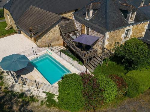 - une vue aérienne sur une maison avec une piscine et des parasols dans l'établissement Les prestins, à Terrasson