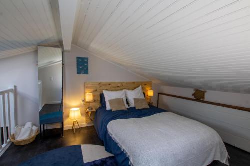Un dormitorio con una cama grande con sábanas azules. en Kaz a muscadelle, en Saint-Laurent-des-Vignes