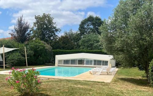 une piscine dans une cour avec un bâtiment dans l'établissement Kaz a muscadelle, à Saint-Laurent-des-Vignes