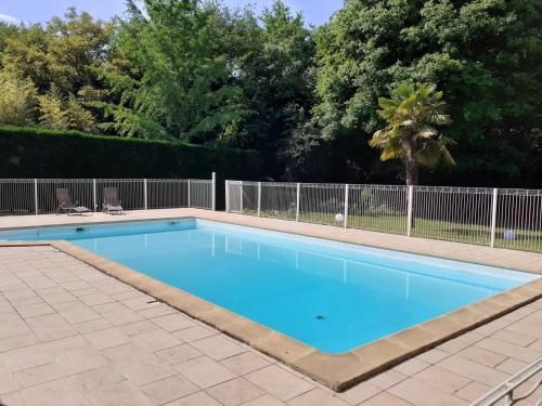 une piscine avec de l'eau bleue dans une cour dans l'établissement Domaine de pommarede, à Carsac-Aillac