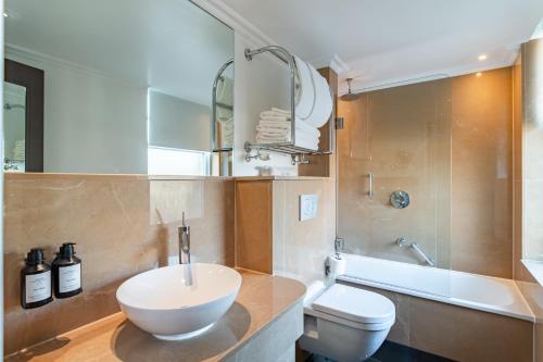 a bathroom with a sink and a toilet at Radisson Blu Hotel, London Bloomsbury in London