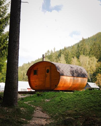 a large wooden boat sitting in a field next to a tree at Chalets & Apartments - Base Camp Medvědín in Špindlerův Mlýn