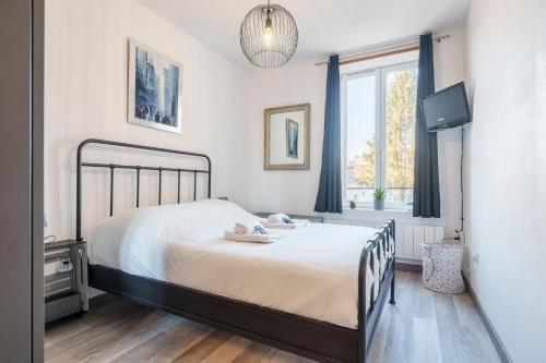 une chambre avec un lit, une télévision et une fenêtre dans l'établissement Le Gaïa - A 10min du centre de Nancy, à Nancy
