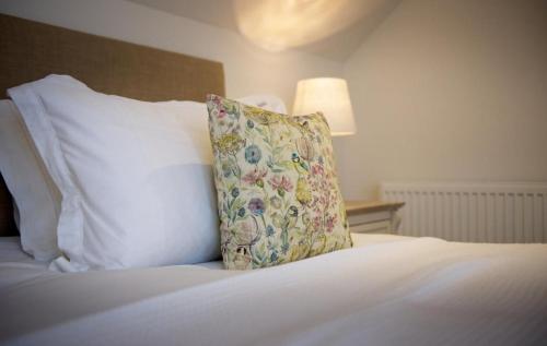 un letto bianco con un cuscino sopra di Curlew Cottage a Gatehouse of Fleet