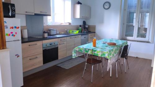 a kitchen with a table with a table cloth on it at Les rosieres 2 in Dom-le-Mesnil