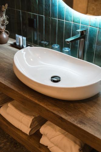 a white sink on a wooden counter in a bathroom at Hoeve BuytenHout in Delft