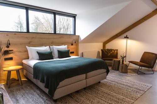 a bedroom with a king sized bed in a room with windows at Hoeve BuytenHout in Delft