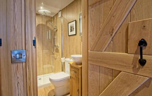 La salle de bains en bois est pourvue de toilettes et d'une douche. dans l'établissement Little Oak, à Gatehouse of Fleet