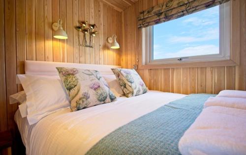 a bedroom with a large bed with a window at Little Beach in Gatehouse of Fleet
