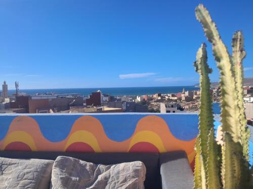 a view of a city from a balcony with a cactus at Buena vista morroco GUEST HOUSE in Tamraght Ouzdar