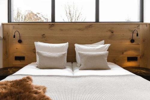 a bed with white pillows and a teddy bear laying on it at Hoeve BuytenHout in Delft