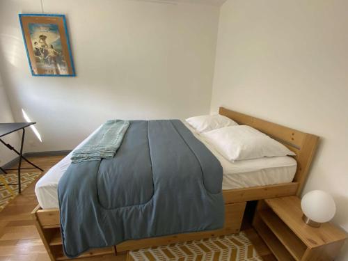 un lit avec un cadre en bois dans une chambre dans l'établissement Appartement VUE MER avec WIFI, loggia, au centre de TREGASTEL - Réf 92, à Trégastel