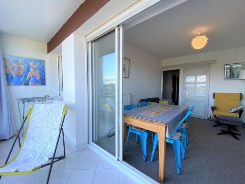 une salle à manger avec une table et des chaises et une fenêtre dans l'établissement Appartement VUE MER avec WIFI, loggia, au centre de TREGASTEL - Réf 92, à Trégastel