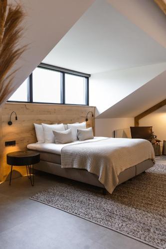 a bedroom with a large bed in a room with windows at Hoeve BuytenHout in Delft