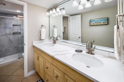 a bathroom with two sinks and a large mirror at Nautilus 1201 - Gulf Front 2 Bedroom Huge Wrap Around Balcony 2nd Floor! in Fort Walton Beach