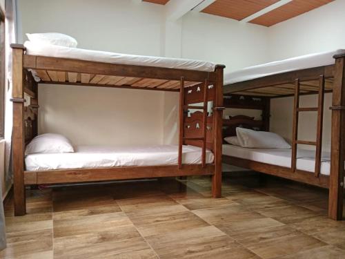 two bunk beds in a room with a wooden floor at Finca la mariana in Pereira