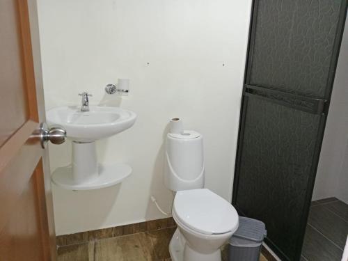a bathroom with a toilet and a sink at Finca la mariana in Pereira