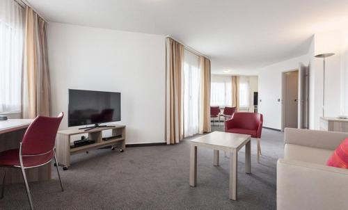 a living room with a couch and a tv at EMA House Serviced Apartments Aussersihl in Zürich