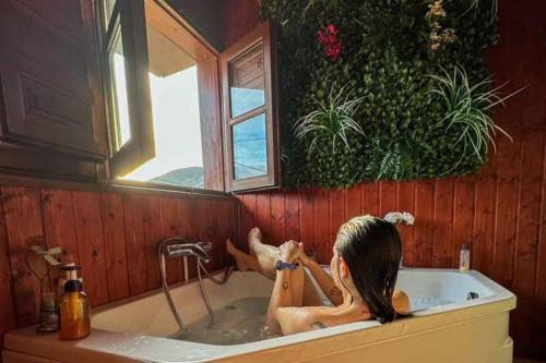a woman in a bath tub with a window at La Congosta, mágica aldea rodeada de montañas in La Plaza