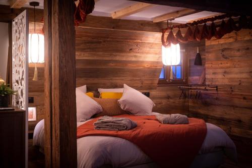 a bedroom with a bed in a room with wooden walls at Suite & SPA 1566 Benfeld in Benfeld