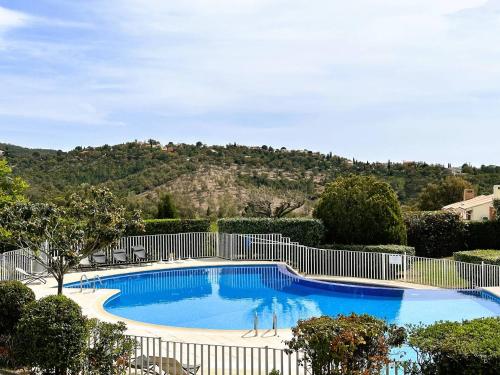 une grande piscine entourée d'une clôture blanche. dans l'établissement Les Medes pour 7 personnes sur le Domaine de Valcros, à La Londe-Les-Maures, à La Londe-les-Maures