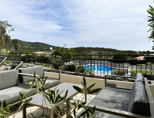 un balcon avec vue sur une piscine dans l'établissement Les Medes pour 7 personnes sur le Domaine de Valcros, à La Londe-Les-Maures, à La Londe-les-Maures