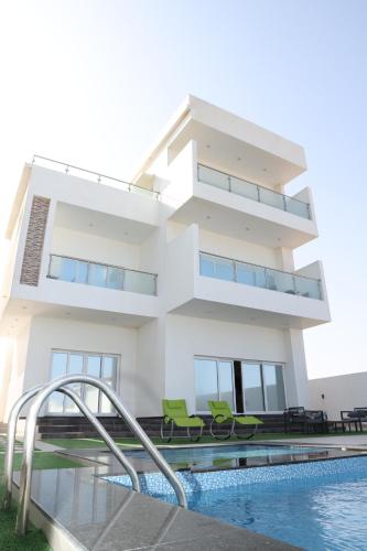 a house with a swimming pool in front of it at شالية ماربيا الاشخرة Marbella Ashkhara Chalet in Al Ashkharah