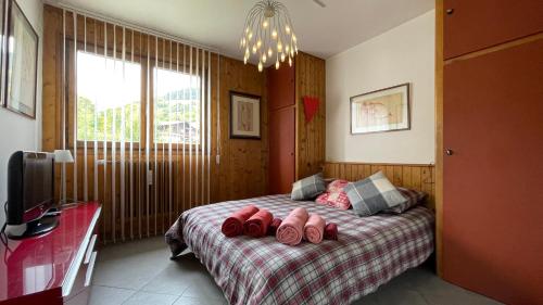 - une chambre avec un lit et des chaussons roses dans l'établissement Flocon U Bon Slo Megeve 2, à Megève