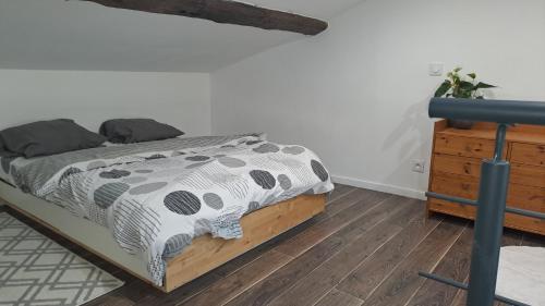 une chambre avec un lit et une commode en bois dans l'établissement Studio Arago, à Roanne