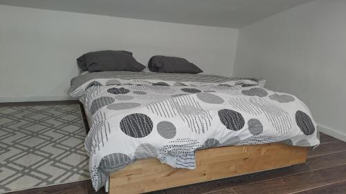 une chambre avec un lit avec une couette noire et blanche dans l'établissement Studio Arago, à Roanne