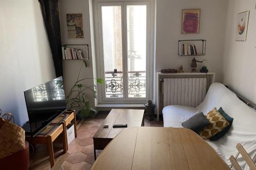 un salon avec un canapé et une table dans l'établissement Lovely love nest in the Marais, à Paris