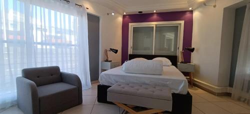 une chambre avec un lit et une chaise dans l'établissement Apartment close to the beach, à Saint-Raphaël