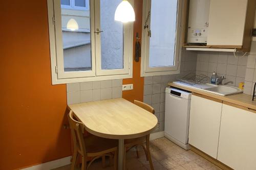 une petite cuisine avec une table et un évier dans l'établissement Lovely love nest in the Marais, à Paris