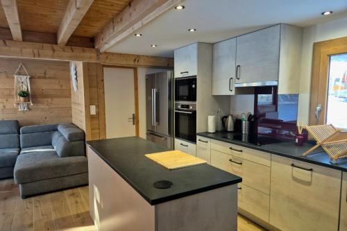 une cuisine et un salon avec un canapé dans l'établissement Magnifique chalet Nordique à La Féclaz - Idéal pour 6 personnes, à La Féclaz