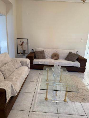 a living room with a couch and a glass table at Between Meteora Trikala BMT House in Tríkala