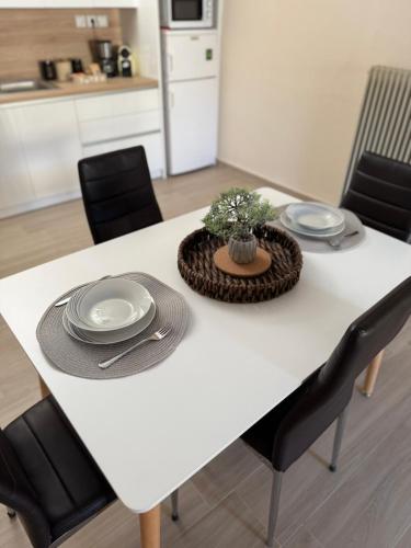 a white dining room table with plates and a centerpiece at Between Meteora Trikala BMT House in Tríkala