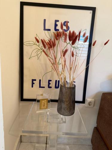 a glass table with a vase with flowers on it at Between Meteora Trikala BMT House in Tríkala