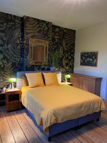 a bedroom with a large bed with yellow pillows at Sambre d'amis in Landelies