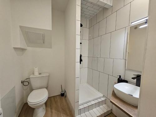 une salle de bain blanche avec des toilettes et un lavabo dans l'établissement Évasion bleue, balcon ensoleillé, à Nîmes